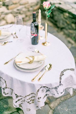 dekorierter Hochzeitstisch mit Wein und rosa Rose