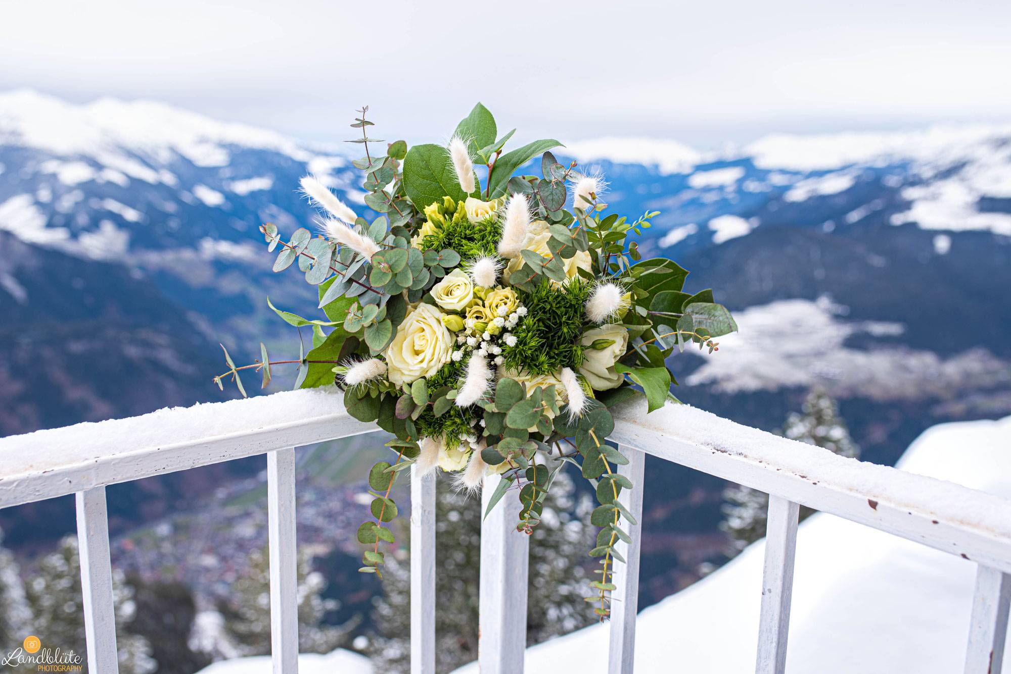 Brautstrauß auf Geländer vor winterlicher Alpenkulisse