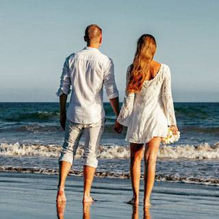 Brautpaar bei einem Spaziergang am Strand vor Meer