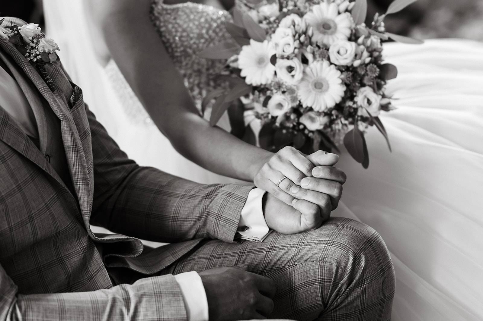 Spartipps für eure Hochzeit: Brautpaar hält gemeinsam Brautstrauß