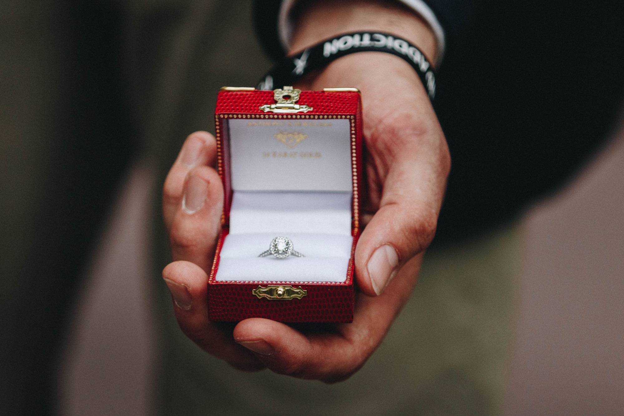 Mann hält beim Heiratsantrag eine Schatulle mit dem Verlobungsring in der Hand