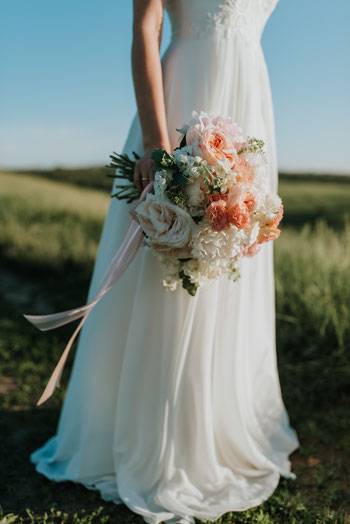 Braut im Brautkleid mit Blumenstrauß