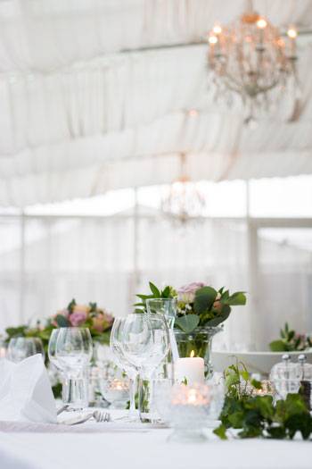 Brauttafel im Festzelt mit Dekoration aus Blumen und Kerzen
